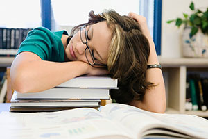Teen girl sleeping on books
