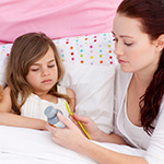Parent giving medicine to child
